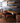 Wooden dining area with chairs and shelves against a gray wall.