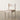 Wooden chair with a cushioned seat on a wooden floor against a white wall.